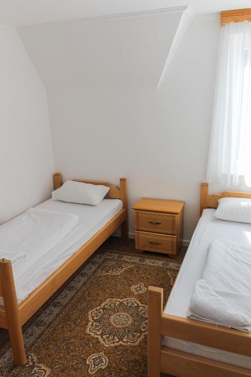 a bedroom with two beds and a table and a window at Oaza Mira Hotel & Resort-فندق ومنتجع واحة الهدوء in Vlasic