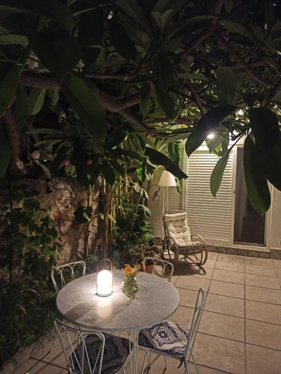 una mesa y sillas con una vela en el patio en Green House Beach, en Mondello