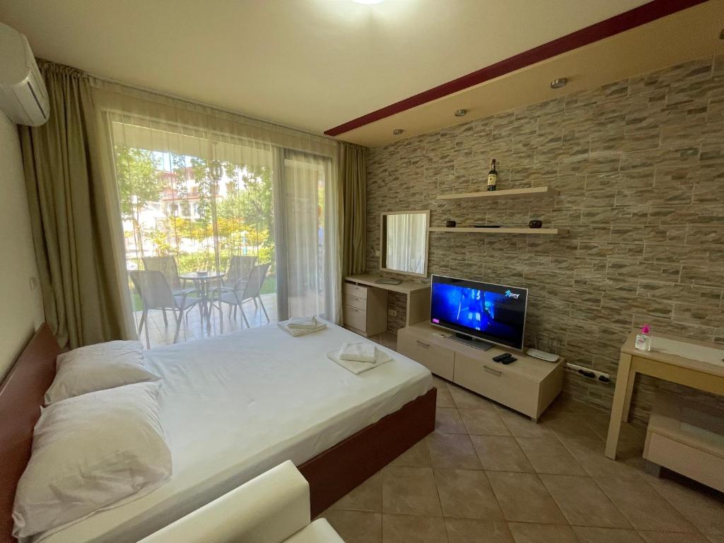 a bedroom with a large bed and a television at Sozopol studio deluxe Green life resort in Sozopol