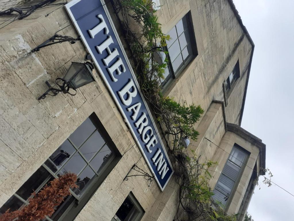 ein Schild für ein Hotel an der Seite eines Gebäudes in der Unterkunft The Barge Inn in Bradford on Avon