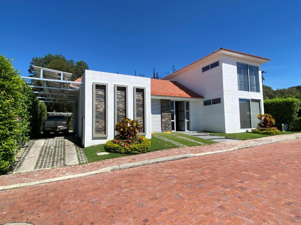 uma casa branca com uma entrada de tijolos em Peñalisa casa vacacional de lujo em Ricaurte