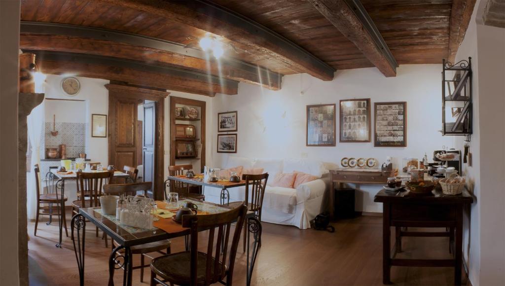 een woonkamer met tafels en stoelen en een bank bij Il Tomolo in Agnone