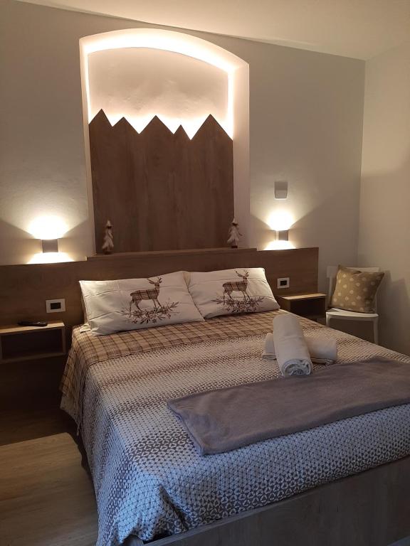 una camera da letto con un grande letto con due cuscini di PERNICI MOUNTAIN HOUSE a Pinzolo