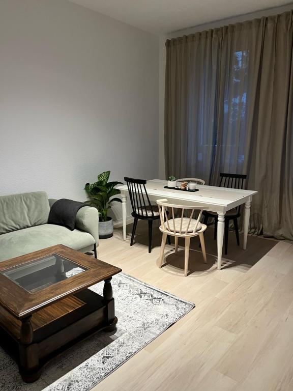 LE-Host في لايبزيغ: غرفة معيشة مع طاولة وكراسي بيضاء