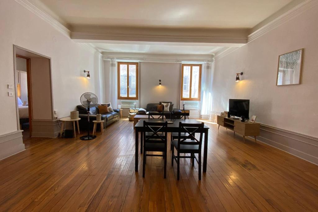 a large living room with a table and chairs at LEtage - Large T3 in the heart of the Old Town of Annecy in Annecy