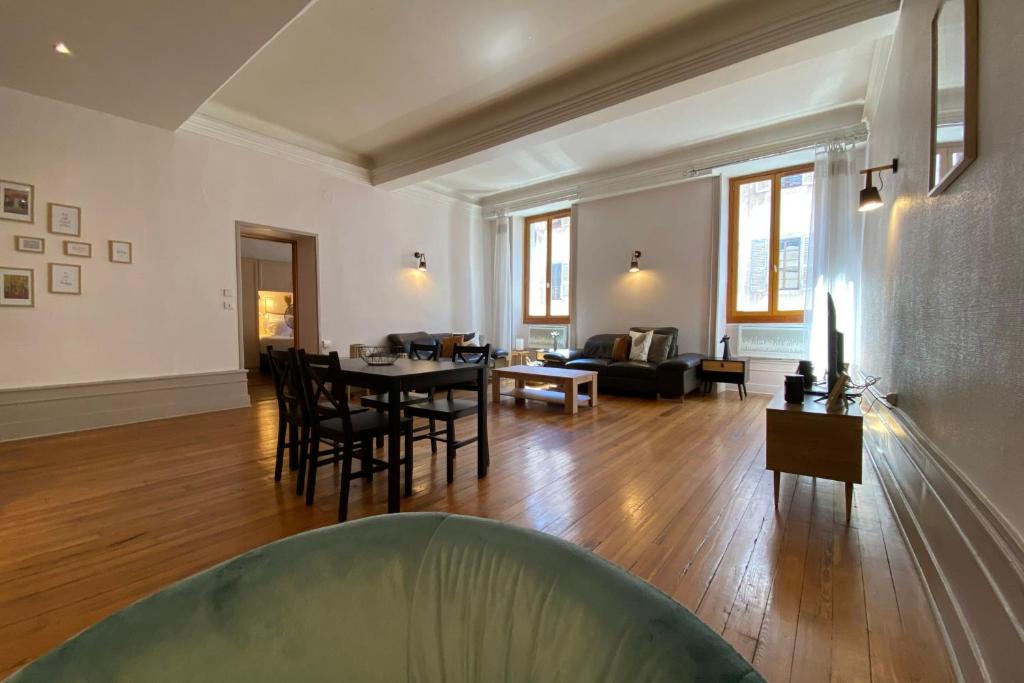 a large living room with a table and chairs at LEtage - Large T3 in the heart of the Old Town of Annecy in Annecy