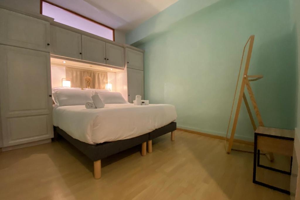 a bedroom with a bed with a window and a ladder at LEtage - Large T3 in the heart of the Old Town of Annecy in Annecy