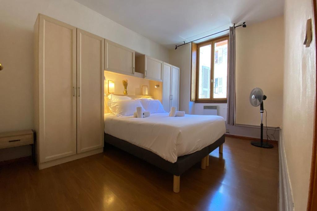 a bedroom with a large bed and a window at LEtage - Large T3 in the heart of the Old Town of Annecy in Annecy