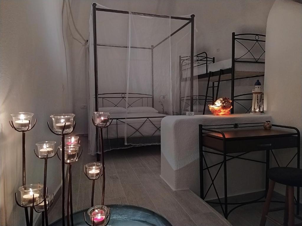 a room with a bed and a table with candles at Mentoras' Complex in Emporio Santorini
