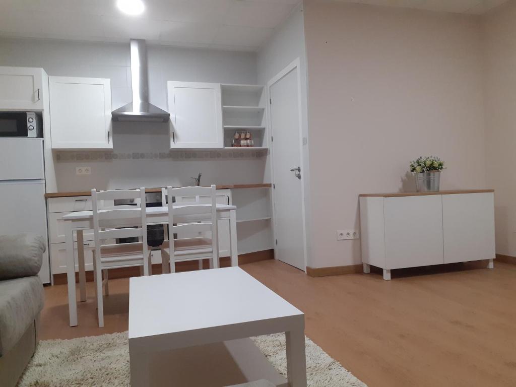 een woonkamer met een tafel en een keuken bij LOFT FRIOL in Friol
