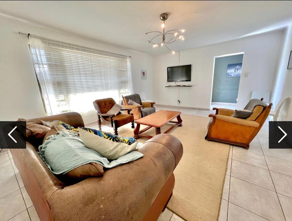 a living room with a couch and chairs and a tv at Vinview 4-bedroom holiday home in Swakopmund