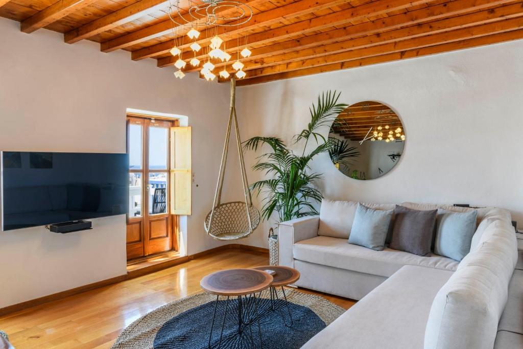 una sala de estar con un sofá y una mesa en Floral Villa with marvelous view to Mykonos town, en Mykonos ciudad