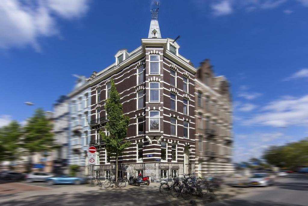 a tall building with bikes parked in front of it at No. 377 House in Amsterdam