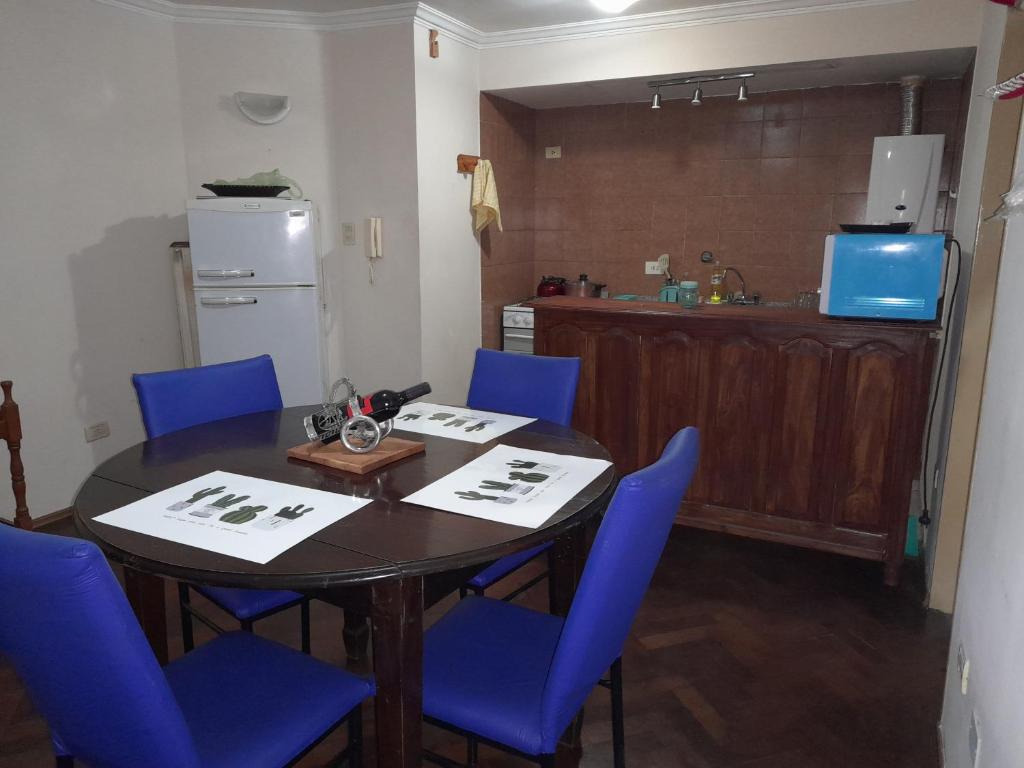 a dining room with a table and blue chairs at Leo IV in San Fernando del Valle de Catamarca