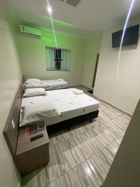 Habitación con 2 camas y mesa. en Hotel Aricanduva en São Paulo