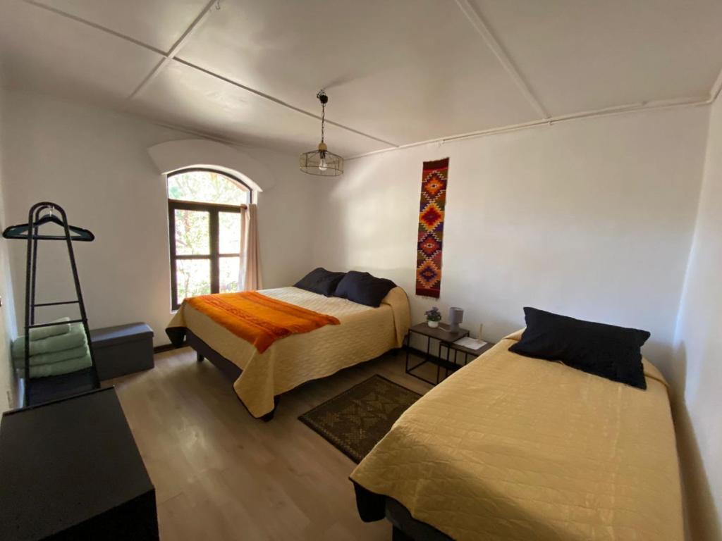 a bedroom with two beds and a window at CaminAndes Hostal in San Pedro de Atacama