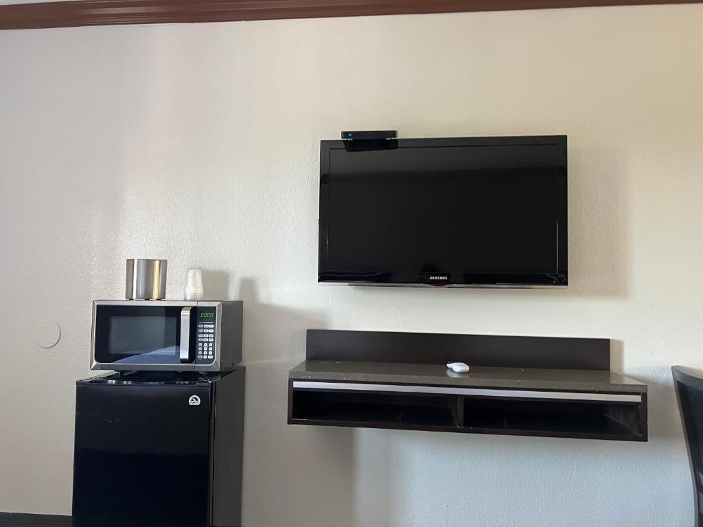 a room with a microwave and a flat screen tv at Starlight Inn Huntington Beach in Huntington Beach