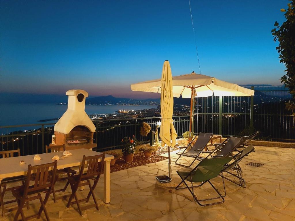 a patio with a table and chairs and an umbrella at Sarina House Ocean View in Lavagna