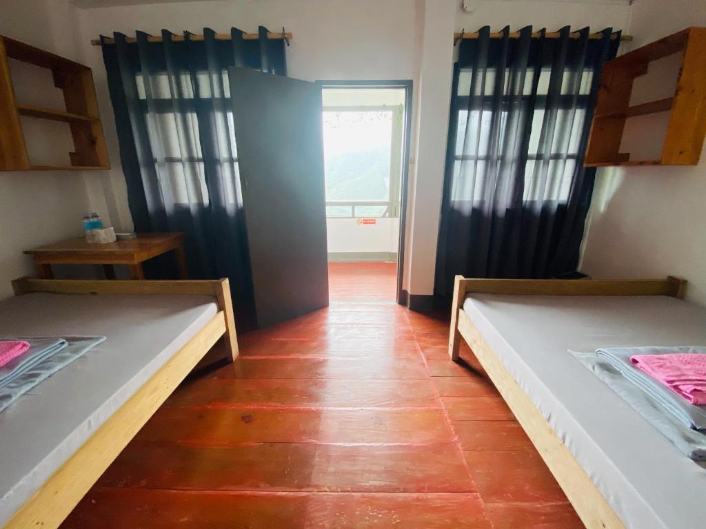 Habitación con 2 camas en una habitación con ventana en Batad Hillside Inn and Restaurant en Banaue