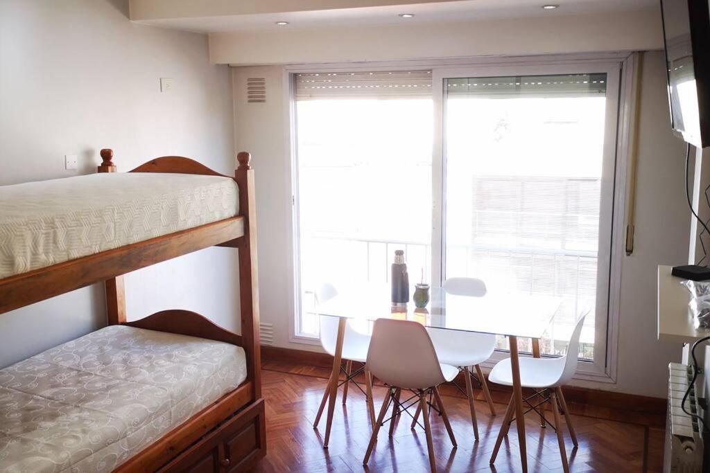 - une chambre avec des lits superposés, une table et des chaises dans l'établissement Hermoso departamento a 30 metros de paseo Balcarce, à Salta