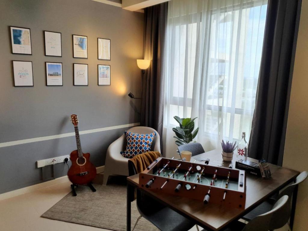 un soggiorno con tavolo e chitarra di The Perfect Getaway @ Tamarind Suites, Netflix 300Mbps a Cyberjaya