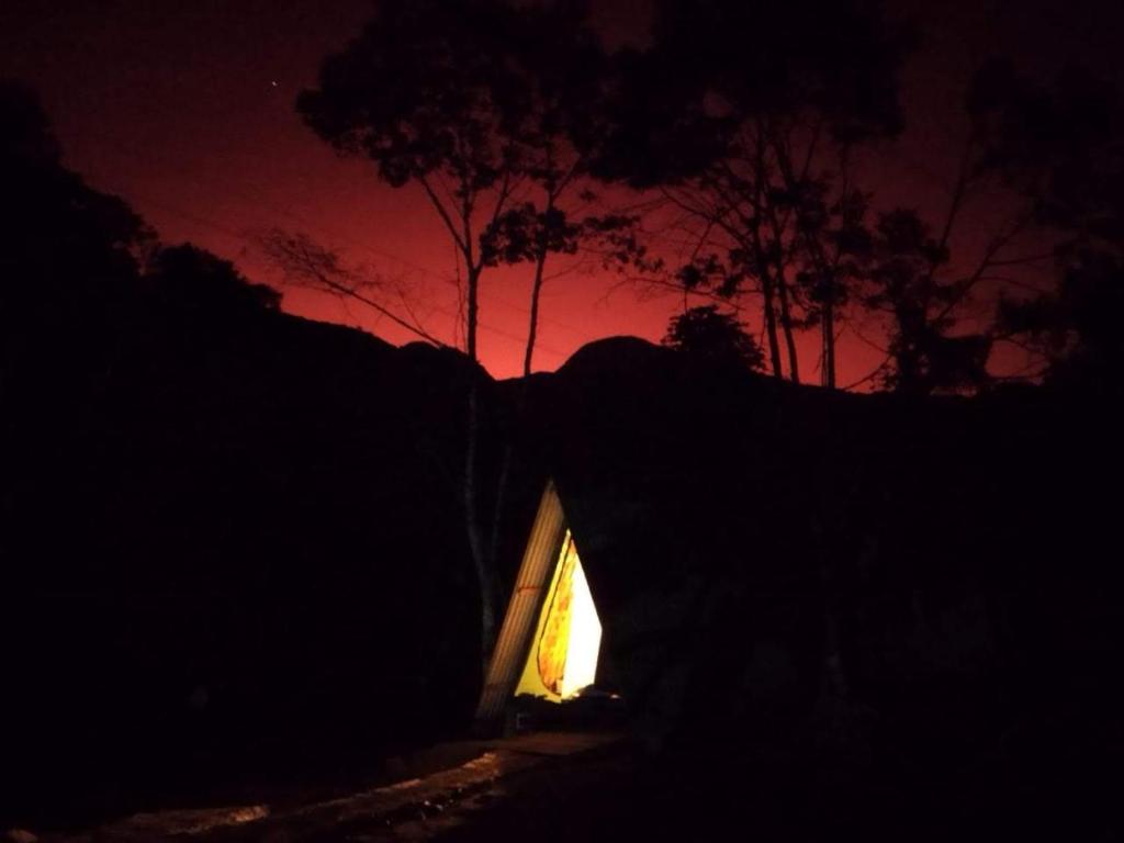 um pequeno quarto com uma janela iluminada à noite em Terras de Maria Bonita em Paraty