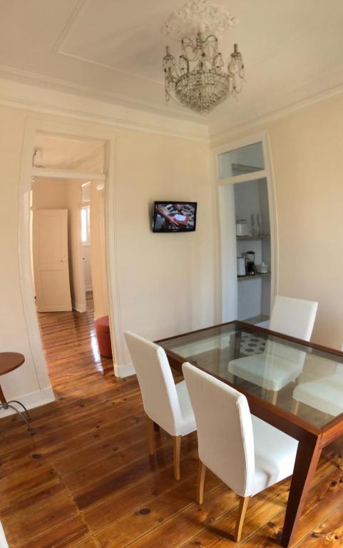 Angels Homes-n27, 3ºfloor - Bairro Típico, Centro Lisboa في لشبونة: غرفة طعام مع طاولة زجاجية وكراسي بيضاء
