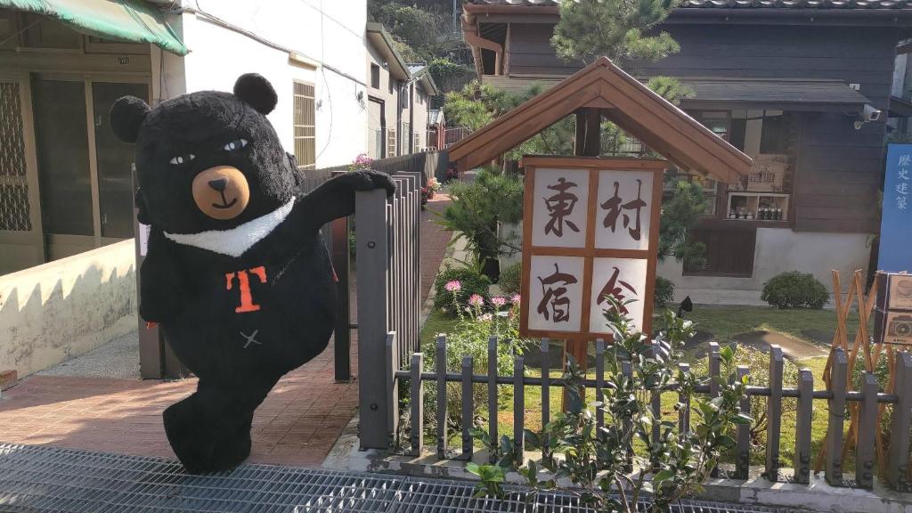 a large black teddy bear standing on a gate at 南庄東村宿舍Nanzhuang Dongchon Homestay in Nanzhuang