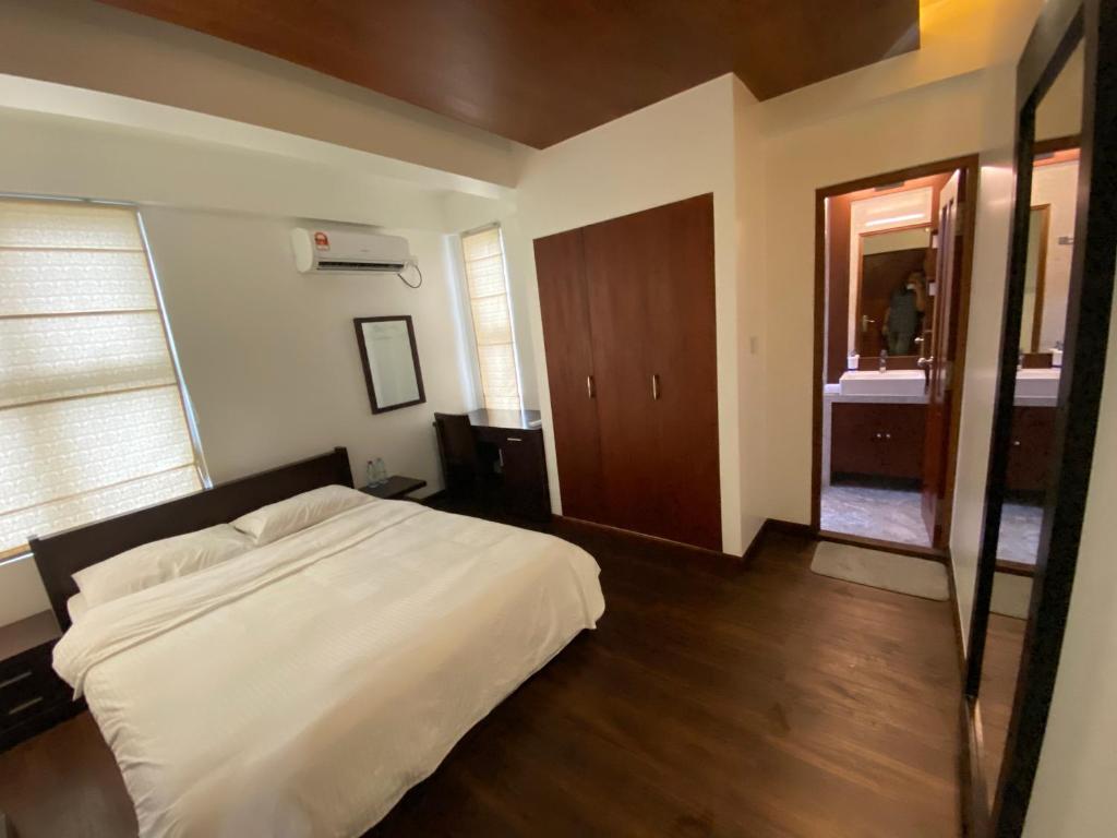 een slaapkamer met een wit bed en een houten vloer bij Luxury 3 Room Apartment by Oboe in Male City