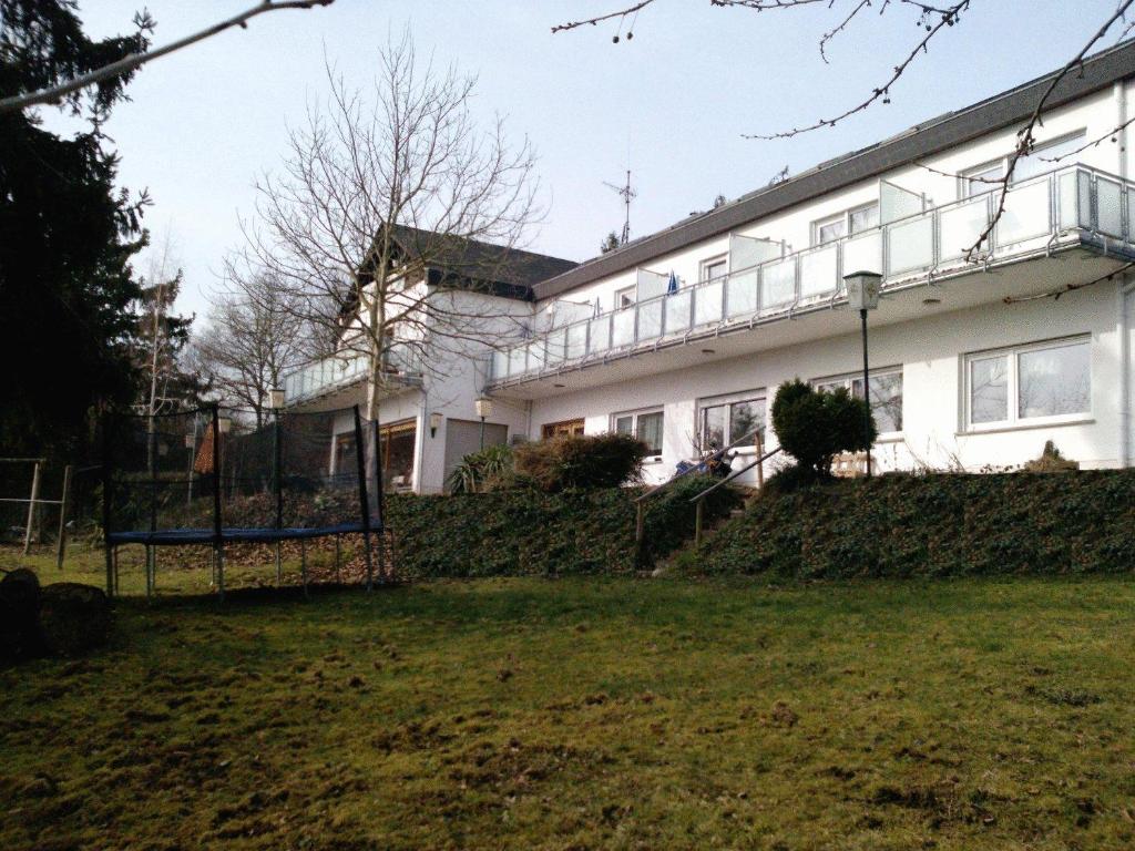 un bâtiment blanc avec une clôture devant lui dans l'établissement Hotel Garni am Bowenberg, à Niederzissen