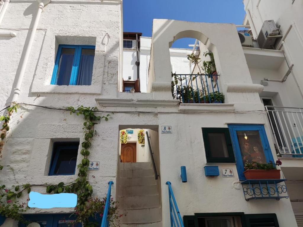 een wit gebouw met een deur en een balkon bij Che bella vita! in Monopoli