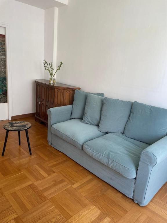 a blue couch in a living room with a table at The cozy apartment in heart of the Nice 1km to sea in Nice