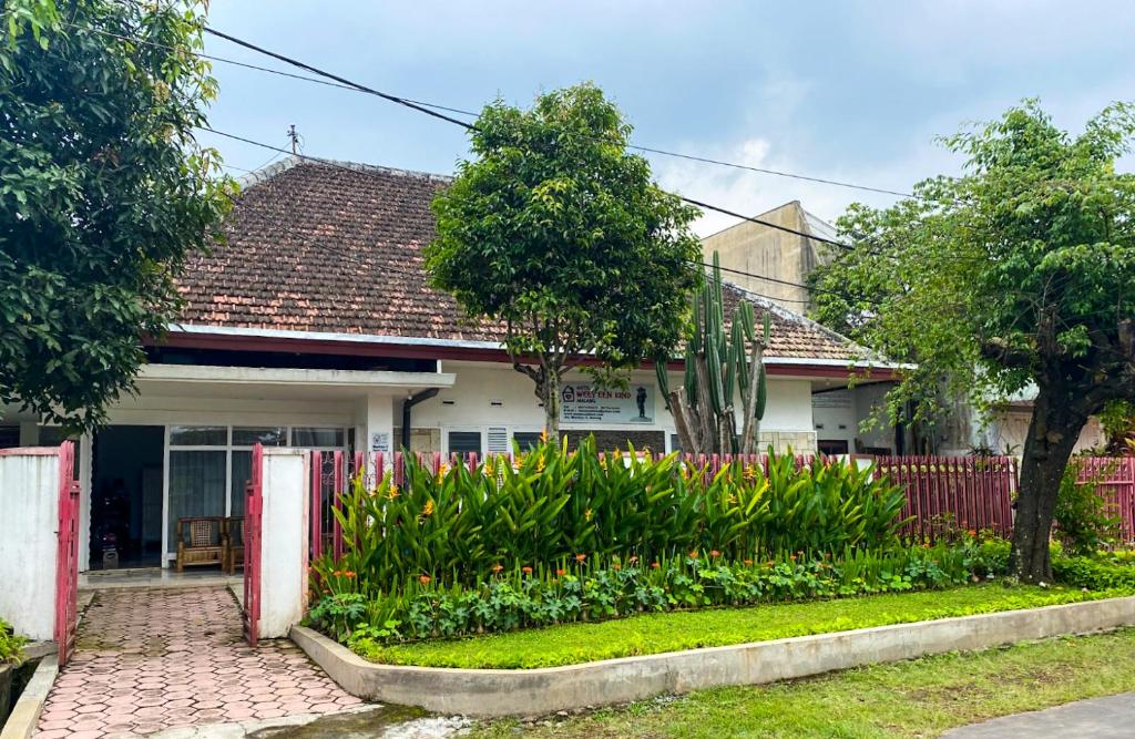 a house with a garden in front of it at Hostel Wees een Kind in Malang