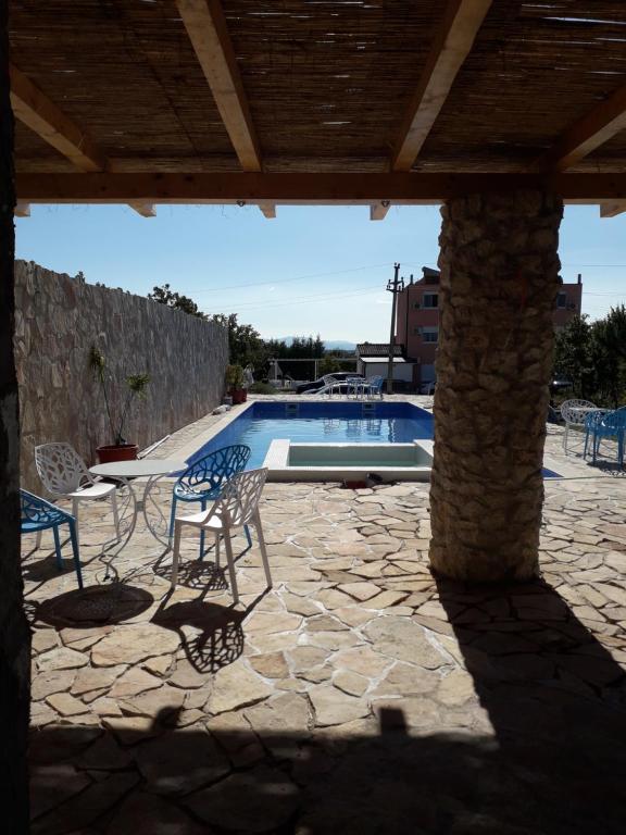 a patio with a table and chairs and a swimming pool at Guesthouse Casa Bevanda in Međugorje