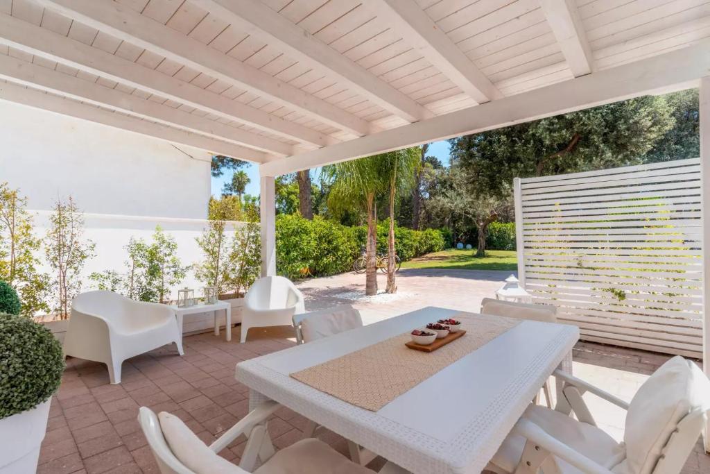 een witte tafel en stoelen op een patio bij Villa Algi in Nardò