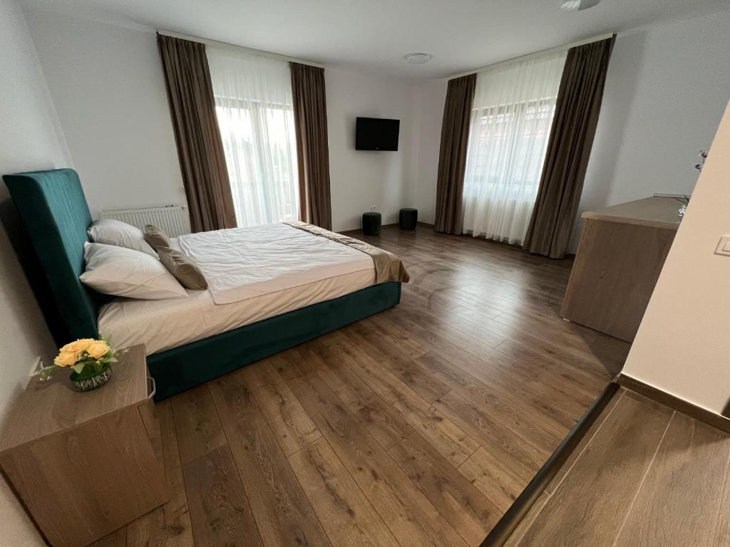 een slaapkamer met een bed in een kamer met houten vloeren bij Aparthotel Plevnei 3 in Cluj-Napoca