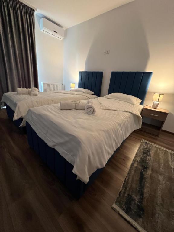 two beds in a hotel room with white sheets at Aparthotel Plevnei4 in Cluj-Napoca