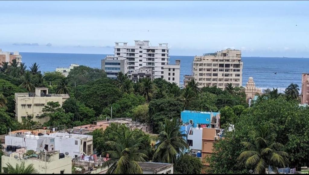 una ciudad con edificios altos, árboles y el océano en Feel Like Home, en Visakhapatnam