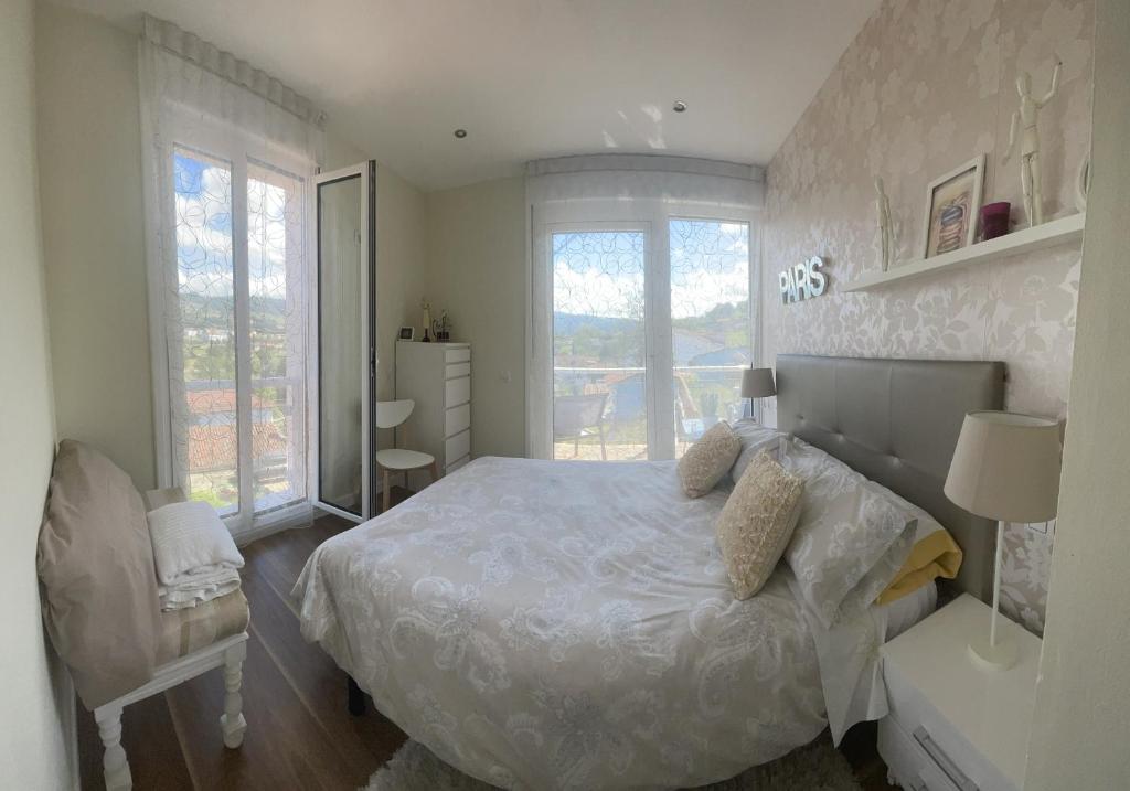 a white bedroom with a bed and a window at Vistalegre78 in Grado