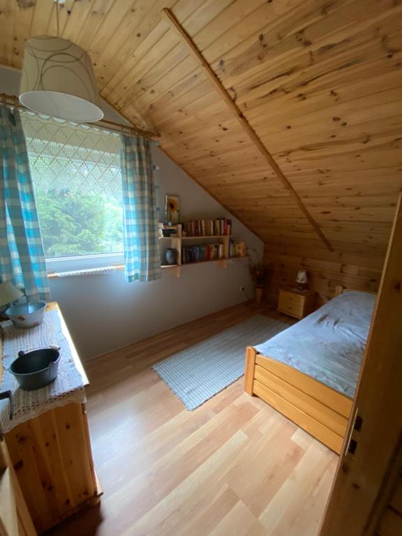 sypialnia z łóżkiem w drewnianym pokoju w obiekcie Mazurskidom Zaścianek w mieście Świętajno