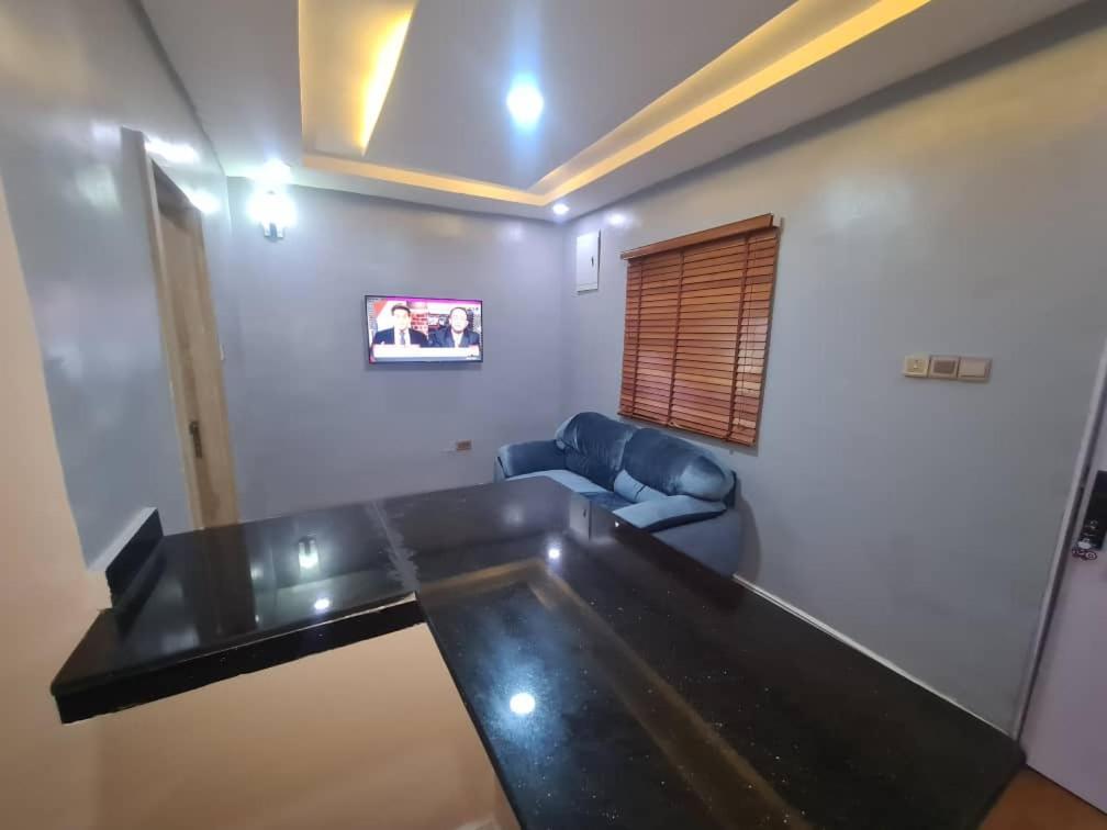 uma sala de estar com uma mesa e um sofá em Wine House, Maitama, Abuja em Abuja