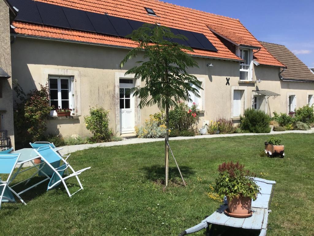 una casa con techo solar, mesa y sillas en Le puits de la Montrée, en Chahaignes