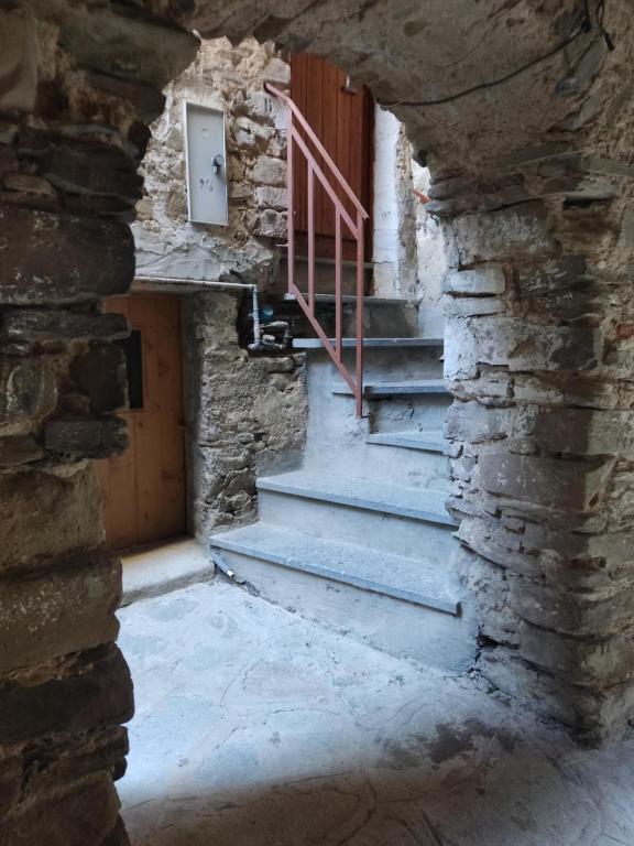 un antiguo edificio de piedra con escaleras y una puerta en Casina vicino al Vico en Vatolla