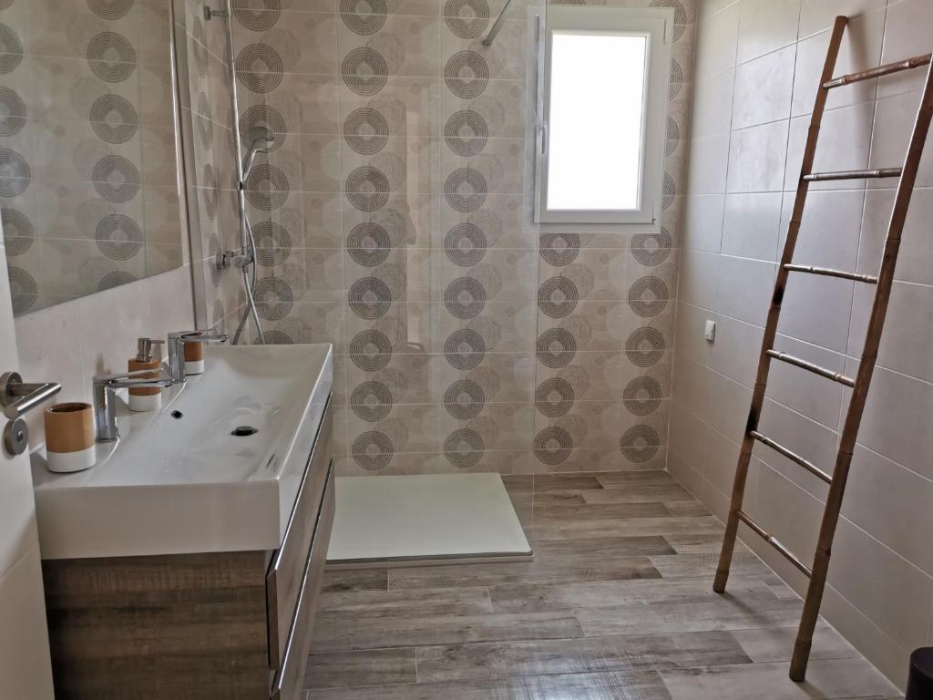 a bathroom with a white sink and a shower at Maison Proche Centre Ville in Biscarrosse