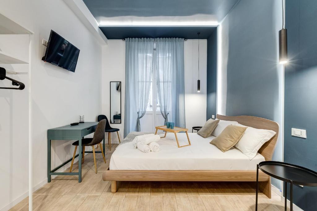 1 dormitorio con cama, escritorio y mesa en COLLINA 24 SUITES - close to VIA VENETO, en Roma