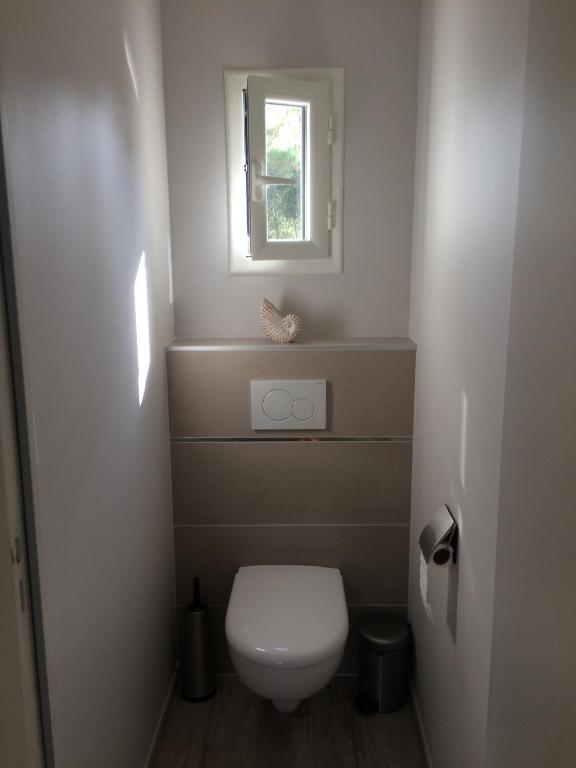 a small bathroom with a toilet and a window at Villa les Chardons in La Baule-les-Pins