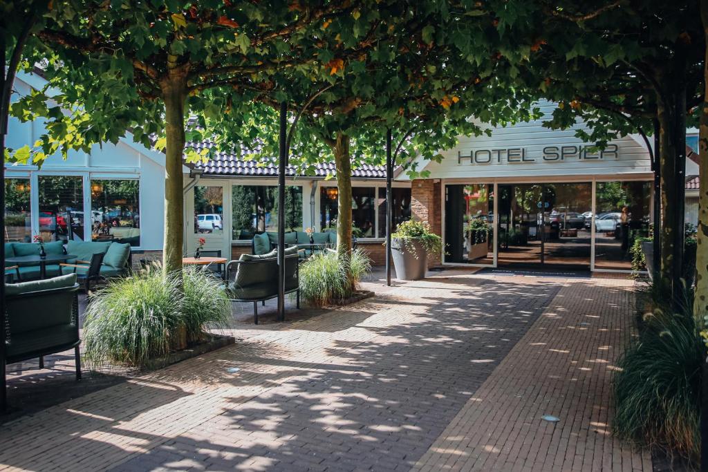 einen Fußweg vor einem Restaurant mit Bäumen in der Unterkunft Hotel van der Valk Spier Dwingeloo in Spier