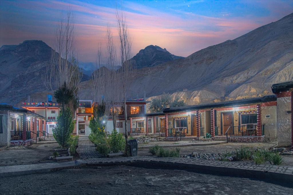 a group of buildings with mountains in the background at Echor Mud Huts Tabo, Spiti Valley in Kaza