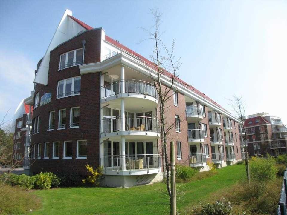 a large brick building on a grassy hill at HP Touristik - Residenz Hohe Lith Neu 3 1 2 in Cuxhaven