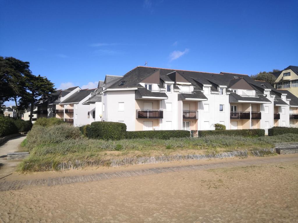 un gran edificio blanco al lado de una playa en Accès direct à la PLAGE de Mr HULOT Saint Marc sur Mer près de La Baule - Parking privé, en Saint-Nazaire